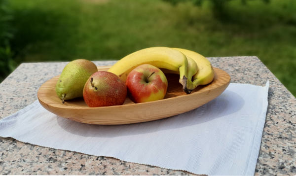Handgefertigte Schale aus Lärchenholz mit Obst auf einem Tisch