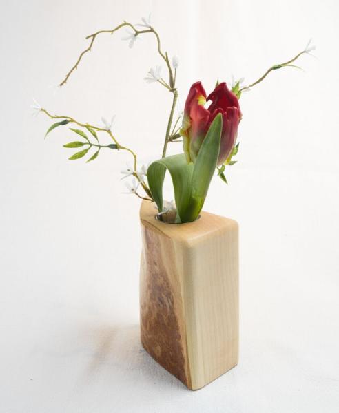 Preview: Handgefertigte Vase aus Ahornholz mit großflächig sichtbarer Baumrinde unter kristallklarem Epoxidharz, bestückt mit einer eleganten weißen Rose
