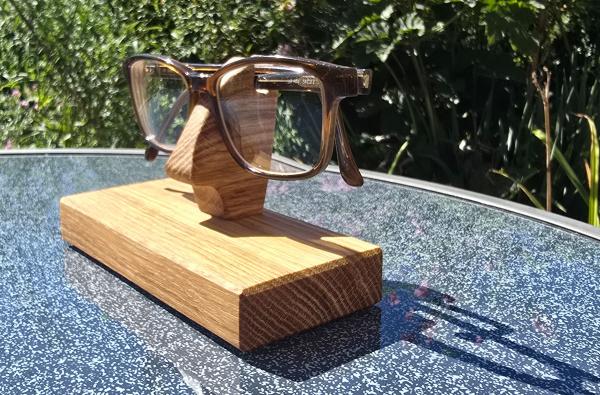 Preview: Handgefertigter Brillenhalter aus Eichenholz mit abgelegter Brille