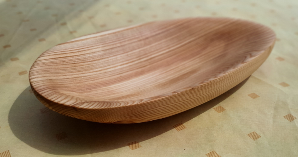 Handgefertigte Schale aus Lärchenholz mit Obst auf einem Tisch