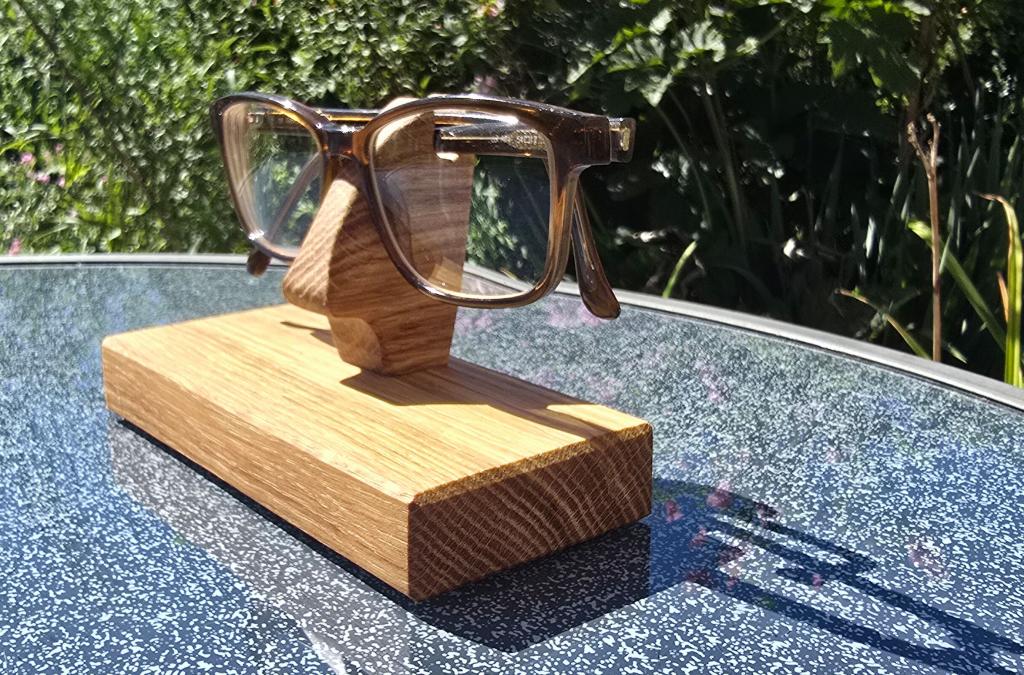 Handgefertigter Brillenhalter aus Eichenholz mit abgelegter Brille